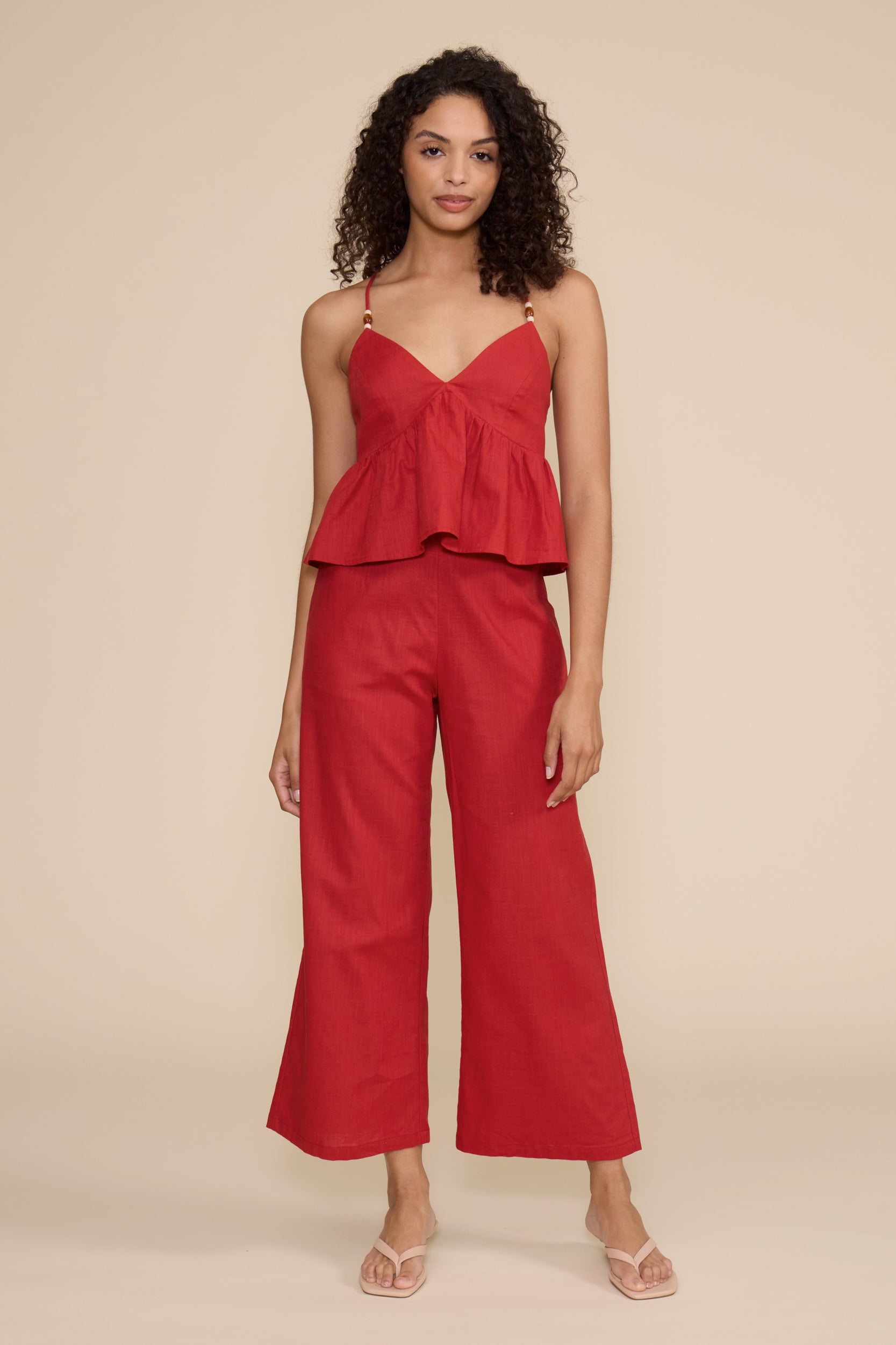 Woman wearing a red set on a beige background